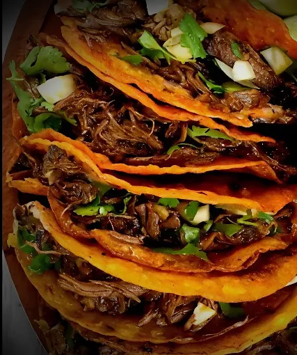 Close-up of Tacos Meza birria tacos with crispy cheese-fried tortillas, tender shredded beef, cilantro and onion